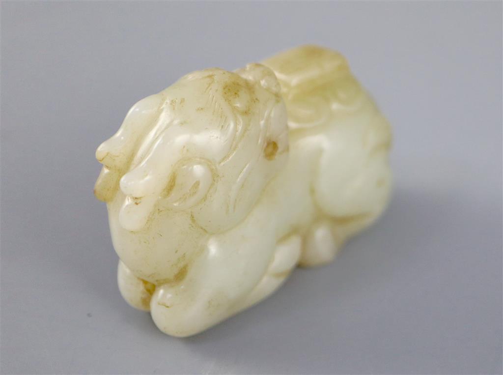 A Chinese pale celadon jade figure of a recumbent qilin, 5.4cm